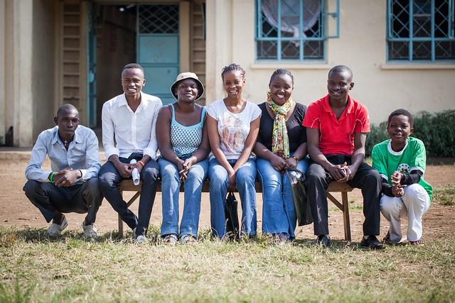 Groupe de personnes souriantes assises ensemble sur un banc