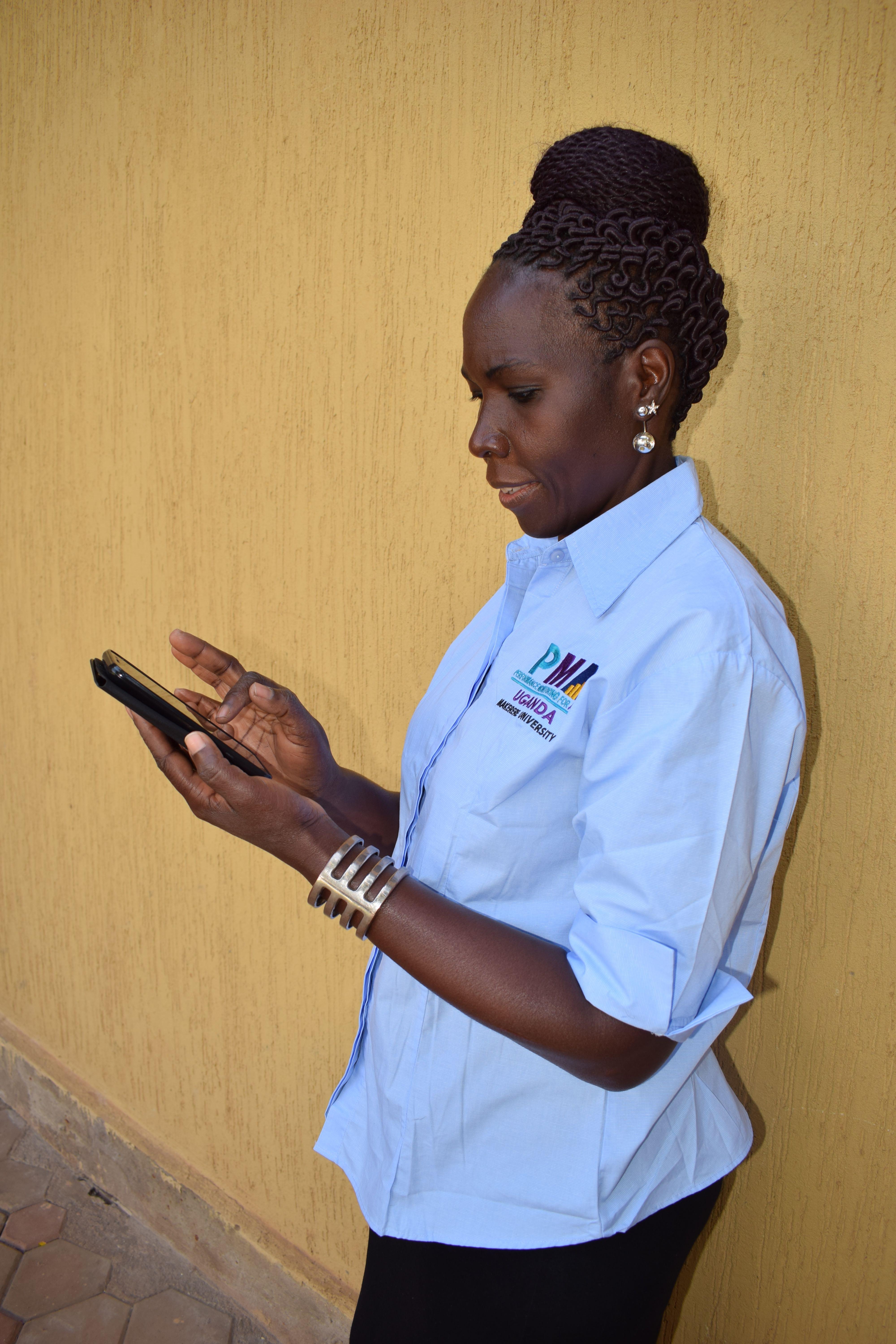 Une Ougandaise travaille sur son téléphone portable